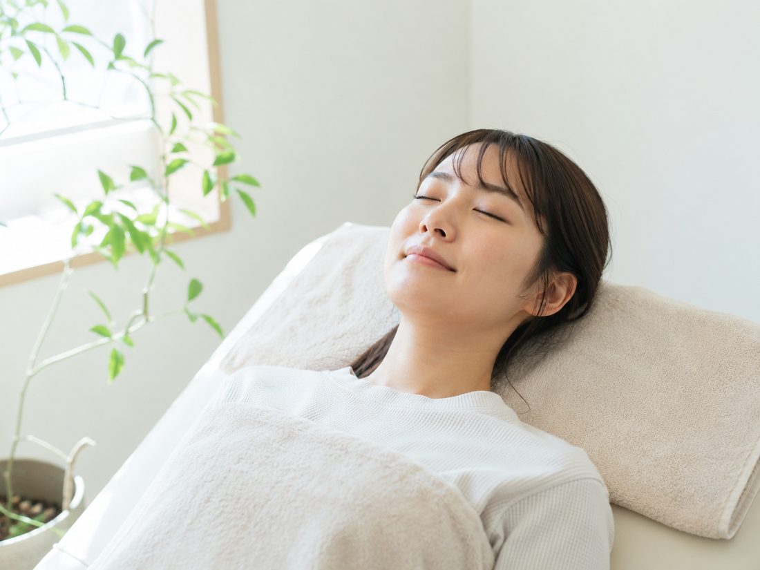 施術ベッドで目を閉じてリラックスする来院者の様子